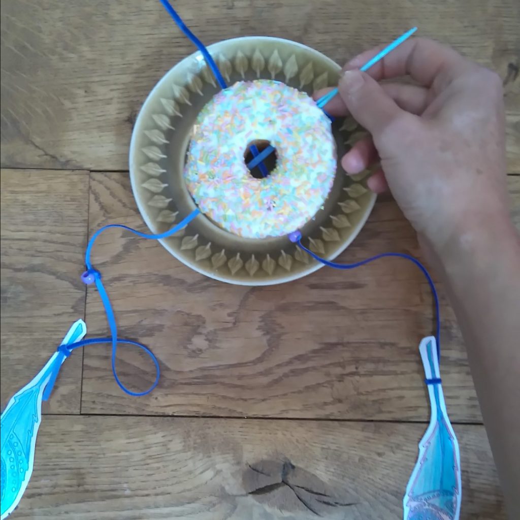 threading ribon thhough your doughnut dreamcatcher party decoration