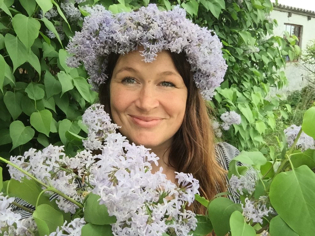 blogger Ulla Lake wearing a simple lilacs flower crown crafted on a warm summer day