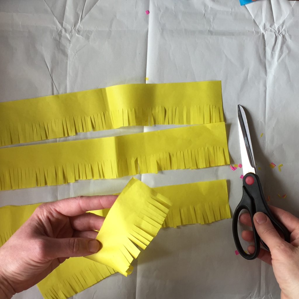 cutting tissue paper fringing for sustainable party crafts diy pinatas