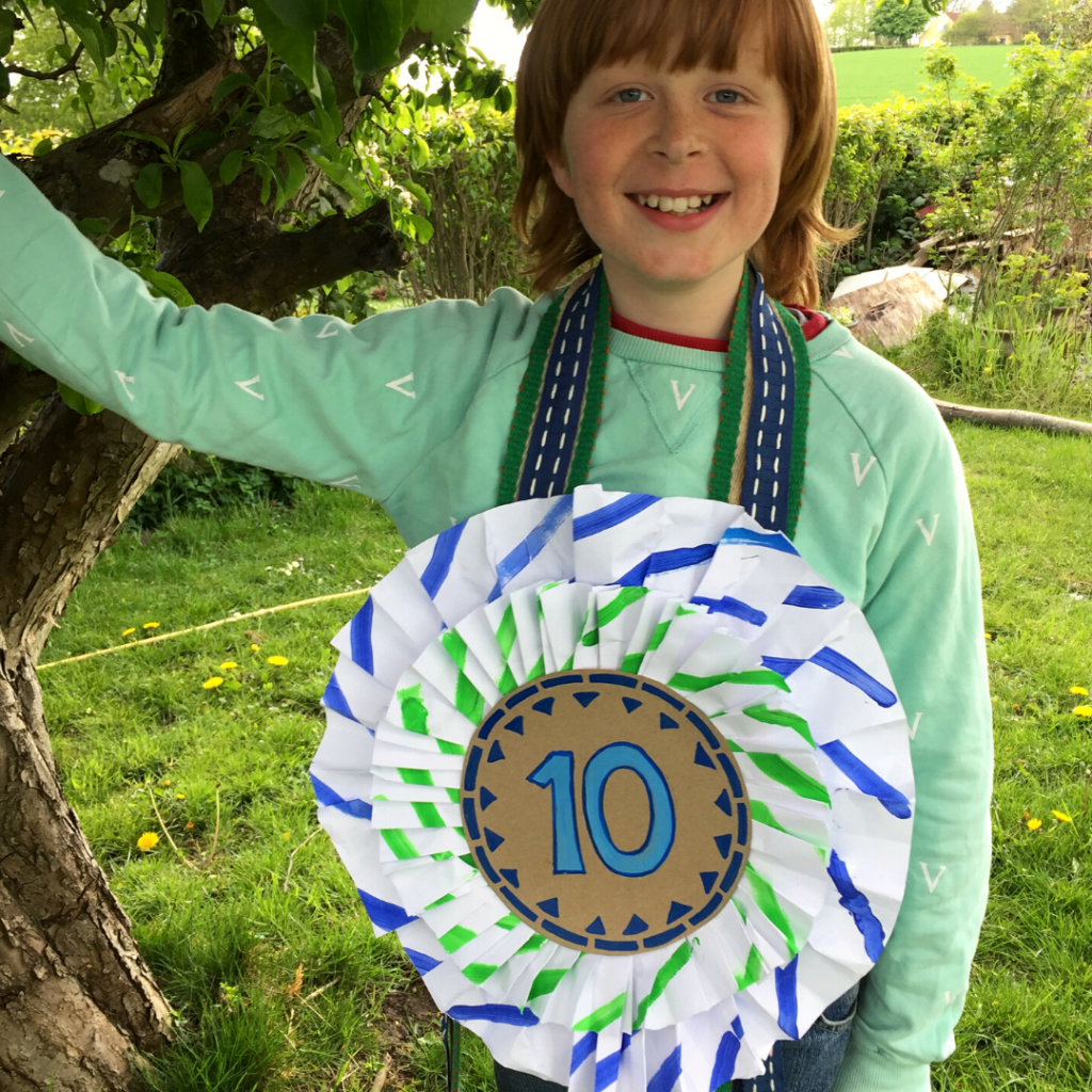 My son wersing the Giant Birthday Rosette I made from a recycled pizza box a sustainable party decoration