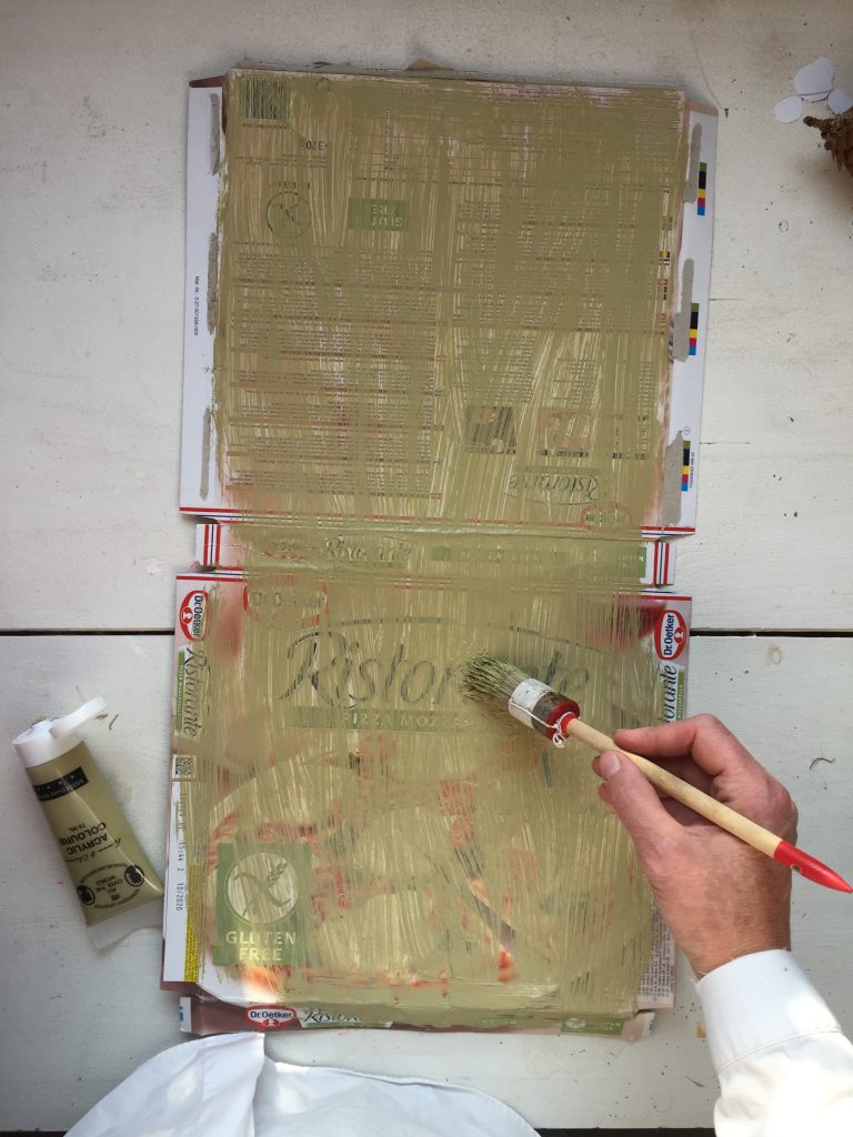 paint your pizza box with acrylic paint to cover up the printed side