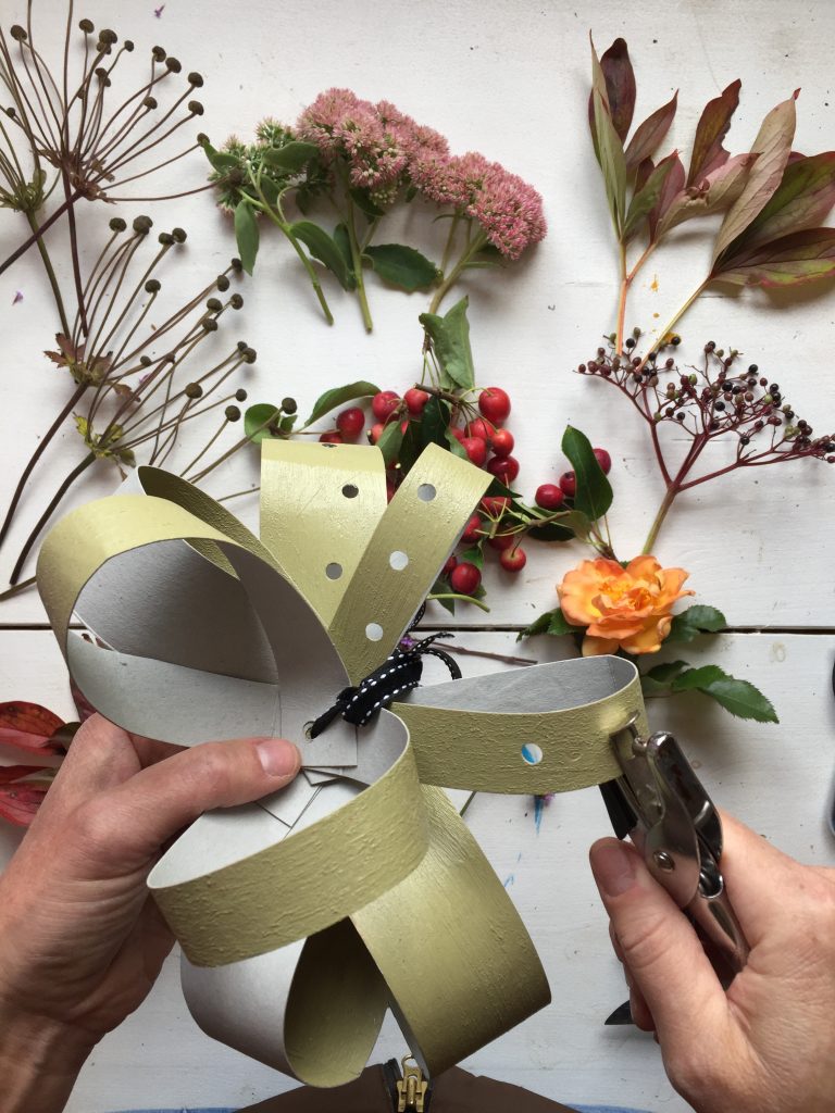 punch holes in your diy recycled cardboard fascinator - ready for inserting your foliage